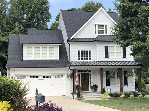 brick and siding house with metal roof|white house black metal roof.